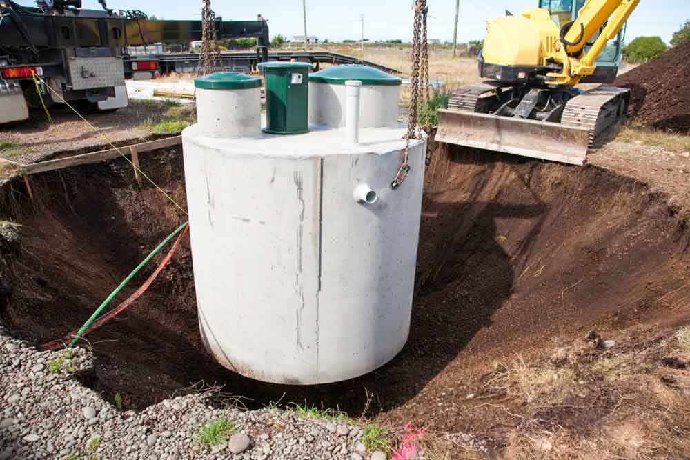 Environmentally friendly septic tank being lowered into ground.